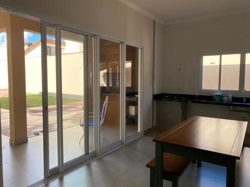 a kitchen with sliding glass doors and a wooden table at Cantinho Aconchegante 2 in Brotas