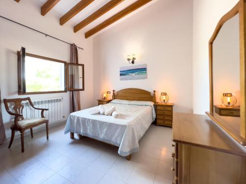 a bedroom with a bed and a chair and a window at Can Pep Yern 1 in Playa Migjorn