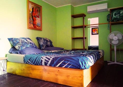 een slaapkamer met een bed met een houten frame bij Poe Matie cosy Studio Papeete, entre Mer et Montagne, proche centre ville in Papeete