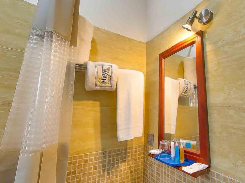 a bathroom with a shower with a mirror and towels at Maya Villa in Oyibi