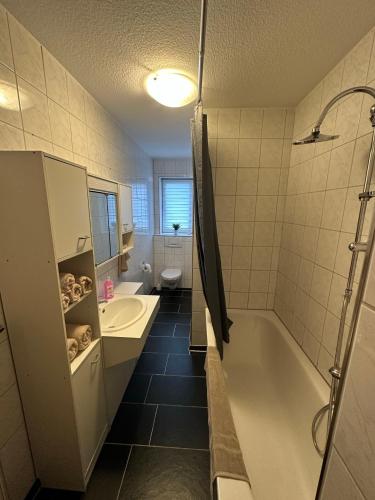a bathroom with a tub and a sink and a toilet at Ferienwohnung Bitterfeld in Bitterfeld