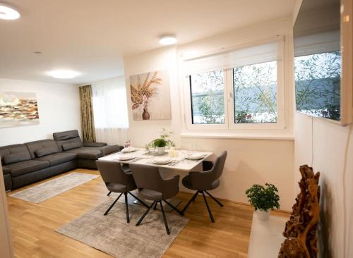 sala de estar con mesa, sillas y sofá en Schönes Living am Donauufer en Viena