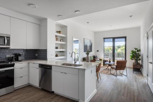 an open kitchen with white cabinets and a sink at Mint House Nashville - The Gulch - Division St in Nashville
