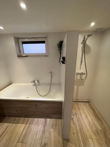 Das Bad ist mit einer Badewanne und einer Dusche ausgestattet. in der Unterkunft Vakantiehuis Eikzicht gelegen aan het bos in Elsloo