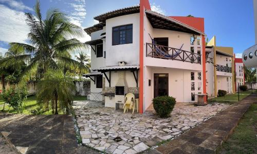 uma casa com uma palmeira em frente em Paraiso de Maracajau em Maracajaú
