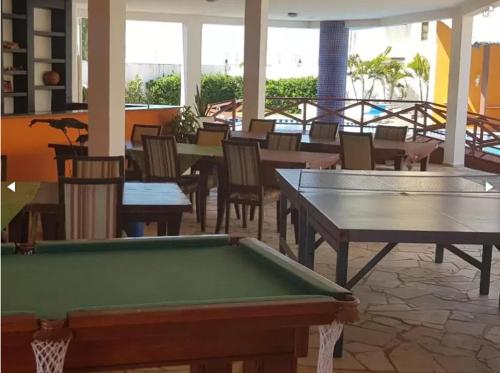 a pool table in a room with tables and chairs at Paraiso de Maracajau in Maracajaú