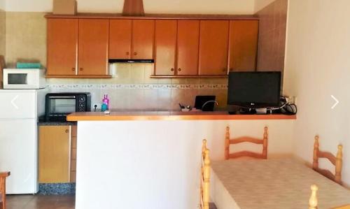a kitchen with wooden cabinets and a counter top at Can Pep Yern 3 in Playa Migjorn