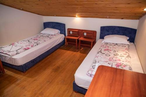 two beds in a room with a wooden floor at Стария Чинар Мелник in Melnik