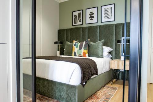 a bedroom with a large bed with a green headboard at Executive Apartment at Ellipse Waterfall in Midrand