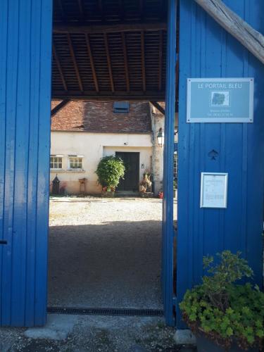 an open door to a building with a blue building at le Portail bleu in Châtres