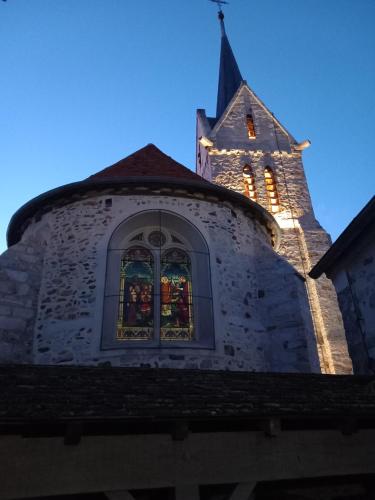 uma igreja com uma janela com luzes de Natal em le Portail bleu em Châtres