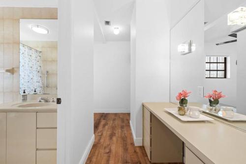 uma casa de banho branca com um lavatório e um espelho em Little Havana Retreat - Newly remodeled Villa by Loan Depot Stadium! em Miami
