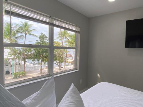 a bedroom with a bed and a large window at Amoray Dive Resort in Key Largo