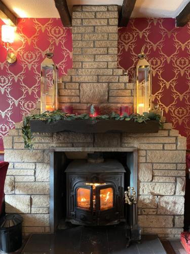 a brick fireplace with a stove with christmas decorations at Dalgarven spa venue in Kilwinning