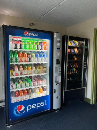 a soda vending machine next to a soda refrigerator at Super 8 by Wyndham Bangor in Bangor