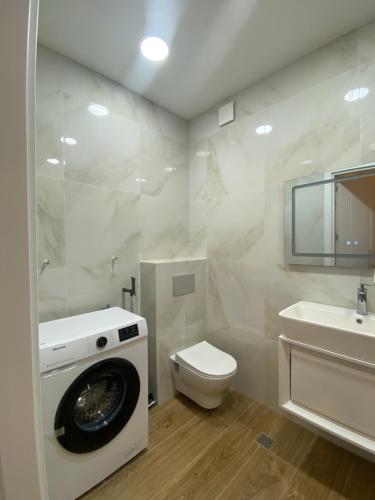 y baño con lavadora, aseo y lavamanos. en River Side Apartment, en Tiflis