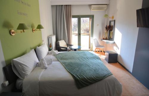 a hotel room with a bed with a green blanket on it at King Alexander in Florina