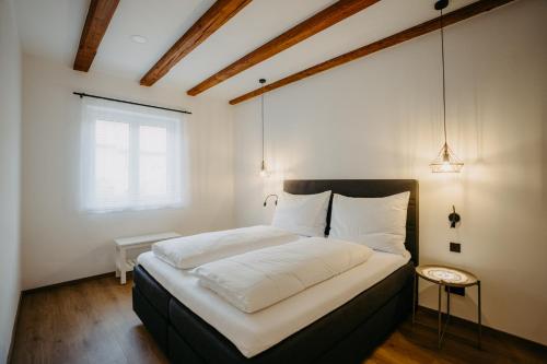 1 dormitorio con 1 cama grande con sábanas blancas en Haus Weiss bei Julia, en Sankt Andrä bei Frauenkirchen