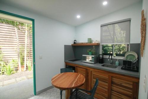 a kitchen with a table and a sink and a window at Tamarindo Bay Boutique Hotel, Apartments & Suites in Tamarindo