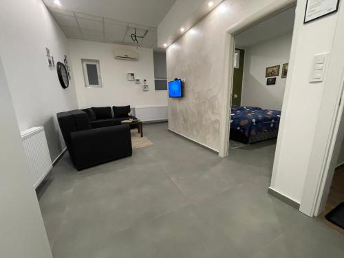 a living room with a couch and a bed at TEPIĆ Garni Hotel in Temerin