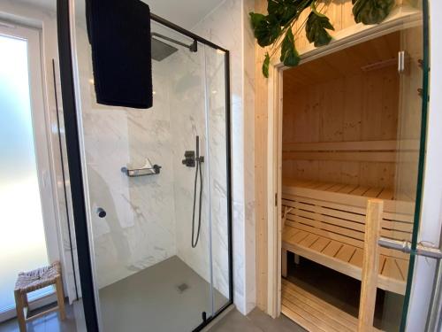 eine ebenerdige Dusche in einem Zimmer mit einer Bank in der Unterkunft Buitengoed de Boomgaard Utrecht - Bunnik in Bunnik