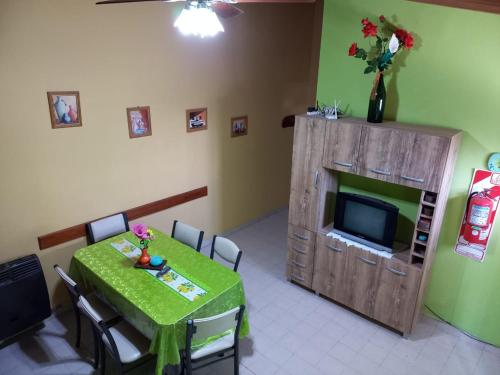 una sala da pranzo con un tavolo e una televisione di CRISNANBEL a Las Grutas