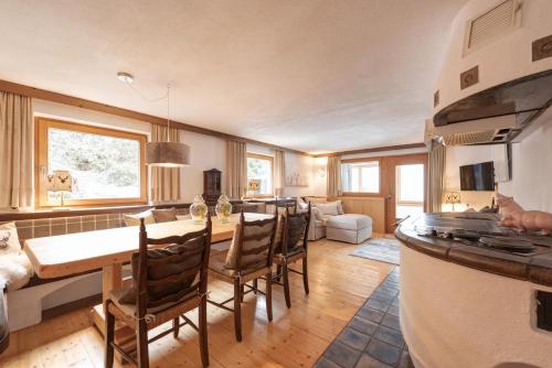 cocina y sala de estar con mesa y sillas en Haus Diel - Premium Apartments mit Küche, en Pettneu am Arlberg