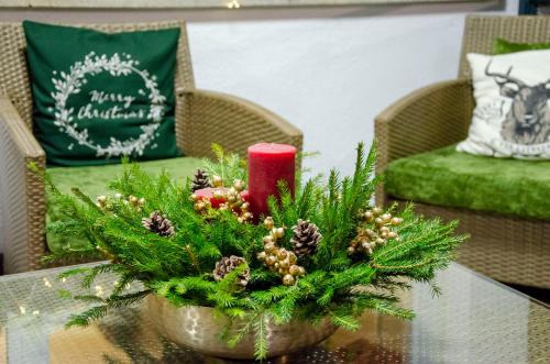 a table topped with a christmas centerpiece with a candle at Hotel Alla Fonte in Arta Terme