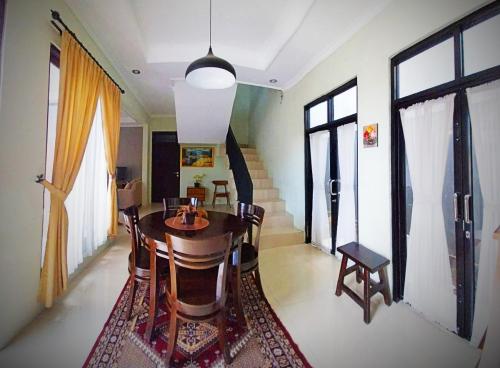 uma sala de jantar com uma mesa de madeira e cadeiras em Gated 3BR Residence - 10 mins from Malioboro em Yogyakarta