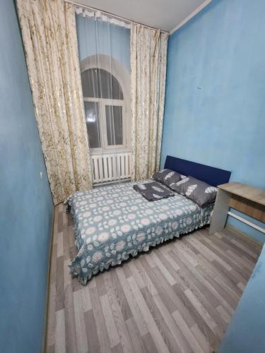 a bedroom with a bed and a window at Оазис in Almaty