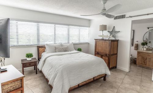 a bedroom with a large bed and a window at SEA MIST - Oceanfront-Lake-Kayak-Paddleboard-Bike in Key Largo