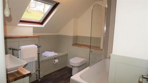 a bathroom with a sink toilet and a window at Barley Cottage - 5* Cyfie Farm with log burner and private covered hot tub in Llanfyllin