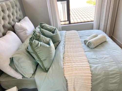 1 cama no hecha con almohadas y una ventana en Langebaan Holiday Home, en Langebaan