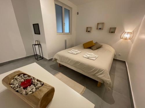 a small bedroom with a bed and a bowl of rocks at Superbe T2 proche de Paris & Disneyland in Ozoir-la-Ferrière