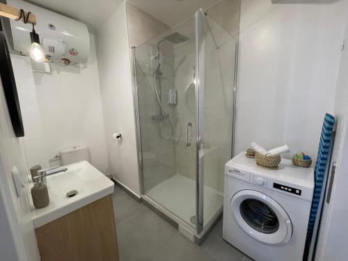 uma casa de banho com um chuveiro e uma máquina de lavar roupa em Superbe T2 proche de Paris & Disneyland em Ozoir-la-Ferrière