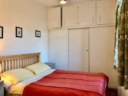 1 dormitorio con 1 cama y armarios blancos en Leazes Cottage, en Rothbury