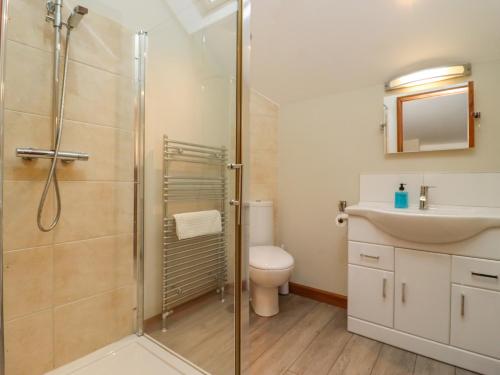 uma casa de banho com um chuveiro, um WC e um lavatório. em The Coach House em Cheltenham