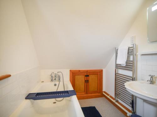 un baño con bañera y lavabo en Waverley, en Lyme Regis