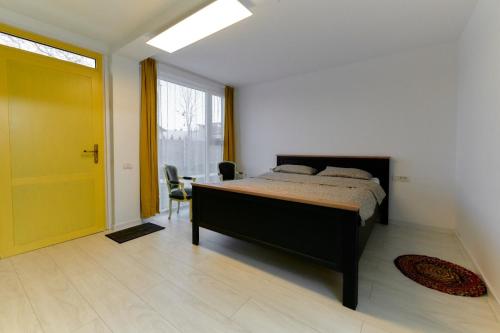 a bedroom with a bed and a yellow door at Pensiune Arada in Arad