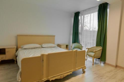 a bedroom with a bed and a window with green curtains at Pensiune Arada in Arad