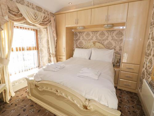 a bedroom with a large white bed with a window at Bryn Berthen in Penrhyndeudreath