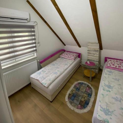 a small bedroom with a bed and a window at Vila Dolina Izvora in Sarajevo