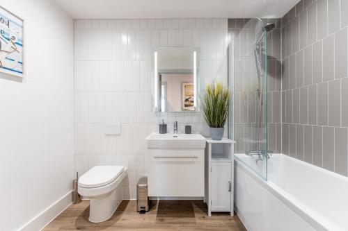 a bathroom with a sink and a toilet and a tub at Azure in Bournemouth