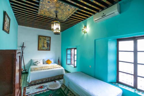 Schlafzimmer mit blauen Wänden und einem Bett in einem Zimmer in der Unterkunft Dar Fez Arabic in Fès