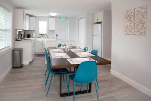 a dining room with a table and blue chairs at Patio I Firepit I 65 TV w/ Netflix I 472mbps I WD in Vero Beach