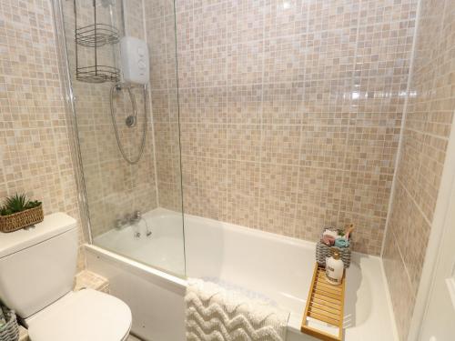 uma casa de banho com um chuveiro, um WC e uma banheira em Drifters Cove em Great Yarmouth