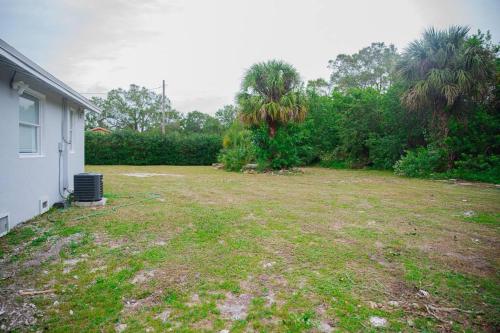 an empty yard next to a house at Patio I Firepit I 65 TV w/ Netflix I 472mbps I WD in Vero Beach