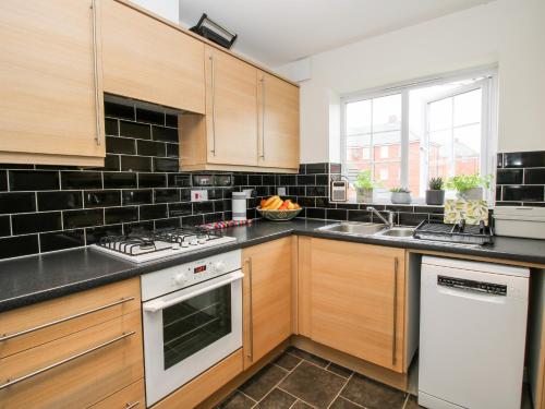 a kitchen with wooden cabinets and a stove top oven at 30 Poplar Close in Shrewsbury