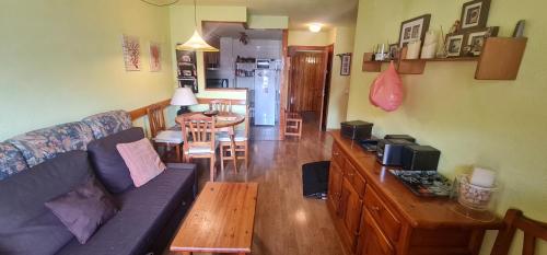 ein Wohnzimmer mit einem Sofa und einem Tisch in der Unterkunft Apartamentos SNÖ Cerler in Aramón Cerler