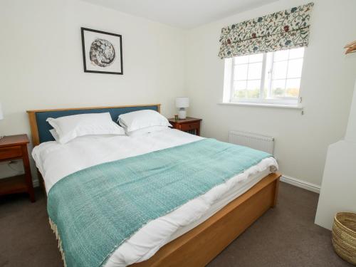a bedroom with a large bed and a window at 30 Poplar Close in Shrewsbury